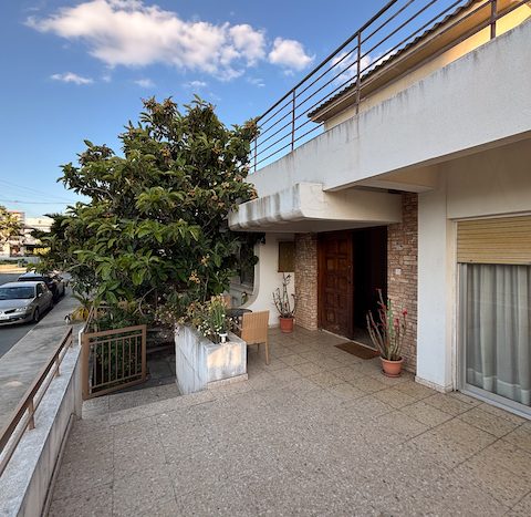 Balcony and entrance of ground-floor house with outdoor seating and potted plants in Limassol.
