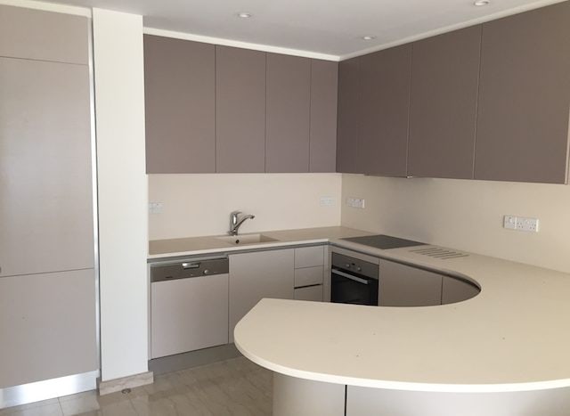 Modern kitchen with neutral cabinetry and built-in appliances in a luxury Limassol Marina apartment.