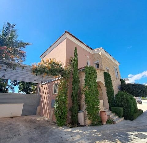 Elegant waterfront villa with lush greenery and Mediterranean architecture in Limassol Marina.
