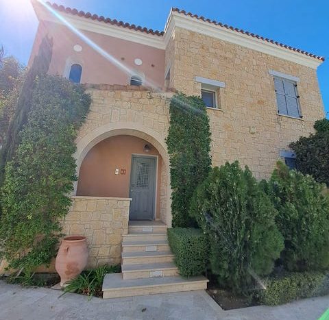 Ultra-luxury waterfront villa in Limassol Marina with elegant stone facade and lush greenery.